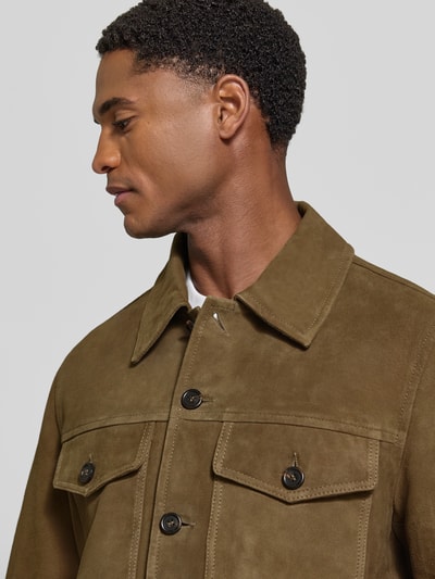 Męski model nosi Regular Fit Lederjacke aus echtem Ziegenleder Modell 'THOM' od Selected, oliwkowa, miękka tekstura, zbliżenie na górną część ciała, kontekst: kurtka skórzana męska/imitacja skóry od Selected