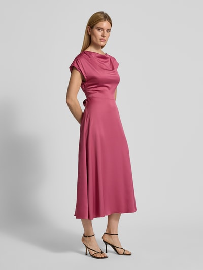 Modelka kobieca ma na sobie Relaxed Fit Midikleid mit Stoffband od Christian Berg Cocktail, satyna, proste wycięcie, pasek, krótkie rękawy, długość tyłu w rozmiarze 36: 126 cm, szerokość w rozmiarze 36: 47 cm, widok całej sylwetki z przodu.