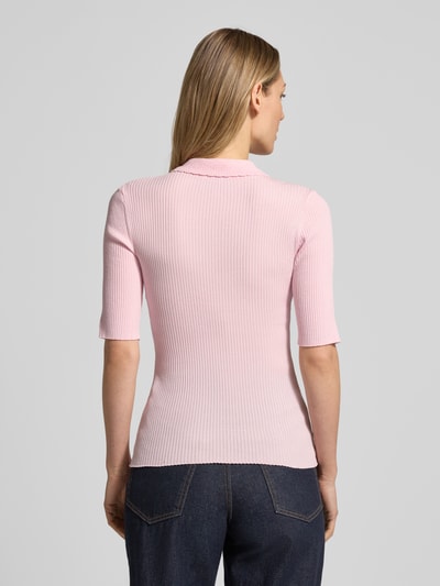 Modelka kobieca ma na sobie Strickshirt mit 1/2-Arm und Polokragen von JAKE*S STUDIO WOMAN, mieszanka lyocellu, dopasowany krój, kołnierzyk polo, listwa guzikowa, drobne prążkowanie, rękaw o dł. 1/2, długość tyłu w rozmiarze S: 56 cm, długość rękawów w rozmiarze S: 28 cm, jasnoróżowy kolor, widok całej sylwetki z tyłu.