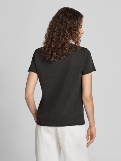Frauenmodel trägt Regular Fit T-Shirt aus reiner Baumwolle 'ONLLUCY' von ONLY in Schwarz zu weißer Hose, Damen T-Shirt von ONLY, Ganzkörperansicht Rückansicht.