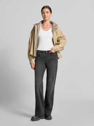 Frauenmodel trägt Slim Fit Langarmshirt aus Baumwoll-Mix Modell 'CHLOE' von VERO MODA in Weiß, kombiniert mit dunkler Hose, Ganzkörperansicht von vorne.