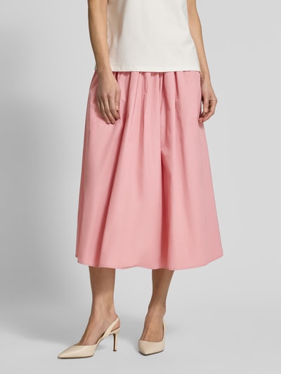 Vrouwenmodel draagt Midirok met elastisch bund van Christian Berg Woman Selection in lichtroze katoenmix met plooien, a-lijn, totale lengte 82 cm, bandwijdte 39 cm. Nahaufnahme onderlichaam.