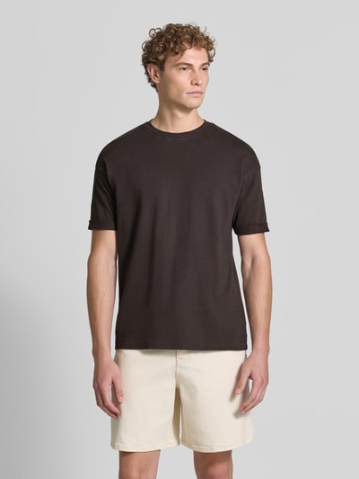 Męski model nosi Regular Fit T-Shirt aus reiner Baumwolle Model 'Thilo' od DRYKORN, czarny, okrągły dekolt, Ganzkörperansicht von vorne.