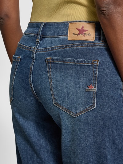 Frauenmodel trägt Jeansshorts mit Umschlag Modell 'Italy' von Buena Vista, Baumwoll-Mix, blaue Struktur, Nahaufnahme Rückansicht.