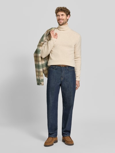Männermodel trägt Slim Fit Rollkragenpullover aus Woll-Mix Modell 'Karl' von Casual Friday, beige Farben, gerippte Textur, Ganzkörperansicht von vorne.