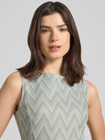 Frauenmodel trägt Regular Fit Jumpsuit mit geometrischem Allover-Stitching von Betty Barclay in hellem Zickzack-Muster, Nahaufnahme Oberkörper. Damen Jumpsuit, Ärmelloses-Design, U-Boot-Ausschnitt, Taillierte Passform, Abnehmbares Stoffband, Rückenlänge 141 cm, Brustweite 32 cm, Gesamtlänge 141 cm, Innenbeinlänge 73 cm.