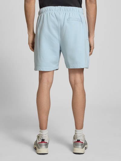 Männermodel trägt Shorts mit Logo-Stitching Modell 'ZANICA' von Ellesse aus Baumwoll-Mix, Relaxed-Fit, hellblau, Ganzkörperansicht Rückansicht.