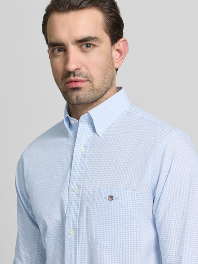 Männermodel trägt Slim Fit Freizeithemd mit Logo-Stitching von Gant in Hellblau mit feinem Karomuster, reine Baumwolle, Nahaufnahme Oberkörper.