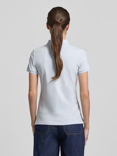 Frauenmodel trägt Slim Fit Poloshirt mit Knopfleiste von Christian Berg Woman, hellblau, Baumwoll-Elasthan-Mix, Seitenschlitze, Rückenlänge 62 cm, Ganzkörperansicht Rückansicht.