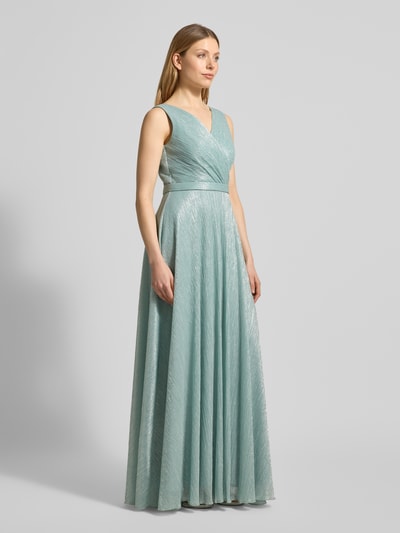 Modelka nosi szimmerndes Abendkleid mit V-Ausschnitt od TROYDEN COLLECTION, krój slim fit, maxi, z taśmą w talii, błyszcząca tekstura, zamek z tyłu, długość tyłu w rozmiarze 36: 160 cm, szerokość w rozmiarze 36: 45 cm, całość w jasnym miętowym kolorze, widok całej sylwetki z przodu.