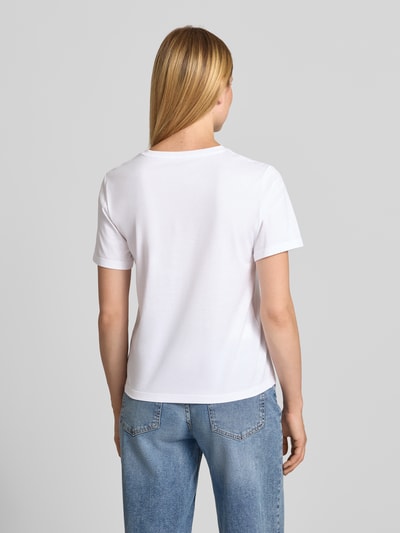 Frauenmodel trägt T-Shirt mit Motiv-Print und Rundhalsausschnitt von Marc Cain in Weiß, reine Baumwolle, Regular Fit, Rückenlänge 58 cm, Ganzkörperansicht Rückansicht.