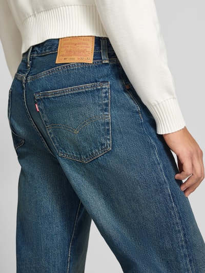 Männermodel trägt Loose Fit Jeans aus reiner Baumwolle Modell '501®' von Levi's®, blaue Denim-Oberfläche, Ganzkörperansicht Rückansicht, Herren Wide & Loose Fit Jeans von Levi's®.