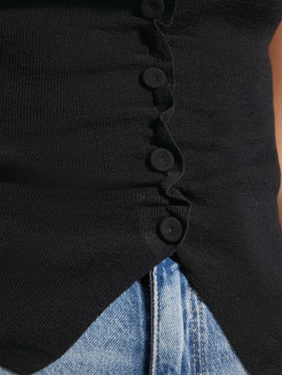 Frauenmodel trägt Strickshirt mit Knopfleiste und Raffungen von JAKE*S STUDIO WOMAN, schwarzer Viskose-Mix, Detailaufnahme.