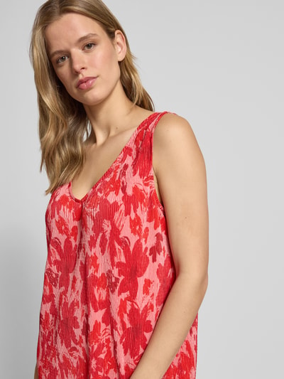 Frauenmodel trägt Fließendes Freizeitkleid mit Allover-Muster von Pieces in Rot und Rosa, Plissee, breite Träger, V-Ausschnitt, Optik:Allover-Muster, Passform: fließend, Mini-Länge, Materialverarbeitung: Plissee, Nahaufnahme Oberkörper.