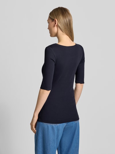 Frauenmodel trägt T-Shirt mit Ärmelaufschlag und Rundhalsausschnitt von Marc Cain aus schwarzem Baumwoll-Mix mit Stretch, Feinripp, körpernah, Rückenlänge 62 cm, Ganzkörperansicht Rückansicht.