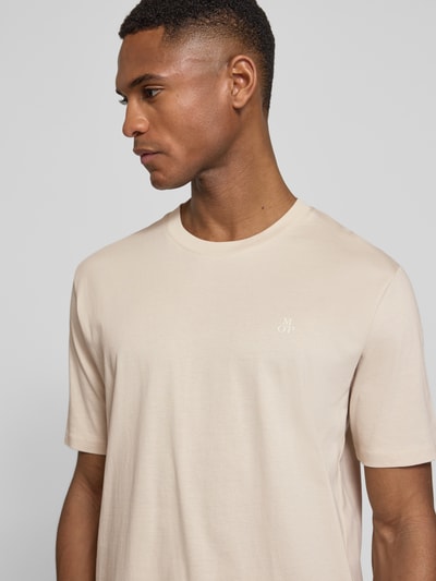 Männermodel trägt Regular Fit T-Shirt aus reiner Baumwolle von Marc O'Polo in Beige mit Logo-Print, Rundhals, Kurzarm, Nahaufnahme Oberkörper.