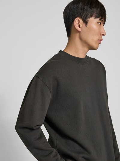Männermodel trägt Sweatshirt mit Rundhalsausschnitt von WON HUNDRED aus reiner Baumwolle, relaxed Fit, dunkel, Nahaufnahme Oberkörper.