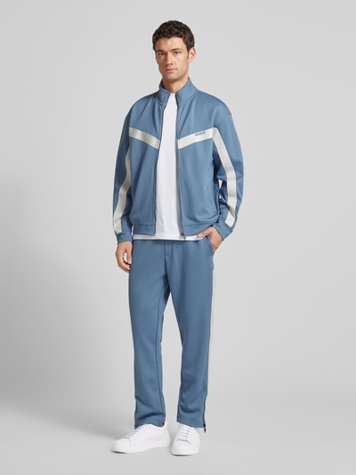 Männermodel trägt Relaxed Fit Jogginghose mit Galonstreifen Modell 'DOLOS' von HUGO, Optik: Unifarben, Sweat, Ganzkörperansicht von vorne.