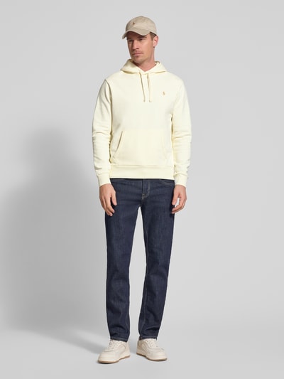 Männermodel trägt Relaxed Fit Hoodie aus reiner katoen van Polo Ralph Lauren, look effen, logodetail, kangoeroezak, capuchon met tunnelkoord, lange mouwen, mouw- en rompzoom geribd, materiaalverwerking sweat, Ganzkörperansicht van voren.