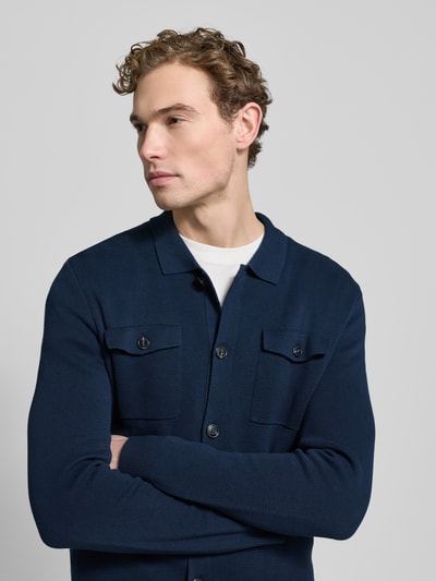Männermodel trägt Strickjacke mit Knopfleiste Modell 'Owero' von JOOP! Collection in Dunkelblau, reine Baumwolle, Nahaufnahme Oberkörper.