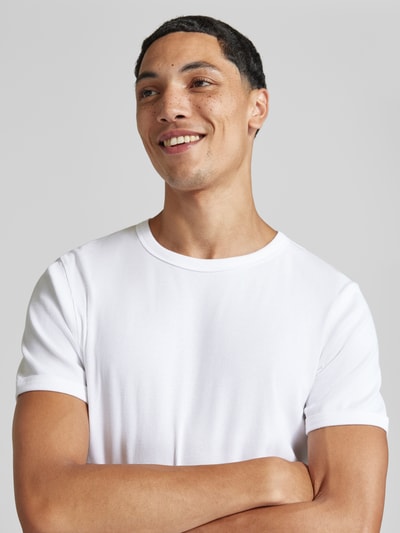 Męski model prezentuje Regular Fit T-Shirt aus Baumwoll-Mix von JACK & JONES, mieszanka bawełny, krój regular fit, okrągły dekolt, z krótkim rękawem, długość tyłu w rozmiarze M: 67 cm, jednolity biały kolor, tekstura gładka, zbliżenie na górną część ciała