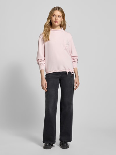 Frauenmodel trägt Sweatshirt mit Stehkragen und Brusttasche von monari in Hellrosa, Modal-Mix, Regular Fit, Ganzkörperansicht von vorne.