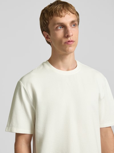 Männermodel trägt Regular Fit T-Shirt aus Baumwoll-Mix Modell 'KIAN' von Only & Sons, Optik: Unifarben, Piqué, Nahaufnahme Oberkörper.