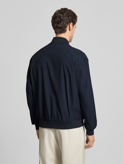 Männermodel trägt Regular Fit Blouson mit Baseball-Kragen Modell 'OSURF' von BOSS Orange in Unifarbe, Ganzkörperansicht Rückansicht.