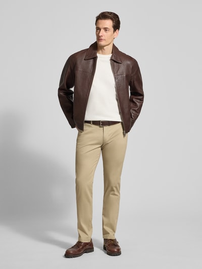 Männermodel trägt Fein strukturierte Chino mit Gesäßtaschen von bugatti in Beige, Baumwoll-Mix mit Stretch-Anteil, Regular-Fit, Ganzkörperansicht von vorne.