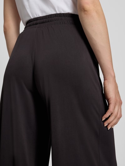 Frauenmodel trägt Straight Fit Stoffhose in verkürzter Passform von Christian Berg Woman, Modal-Mix, elastischer Bund mit Tunnelzug, Nahaufnahme Rückansicht.