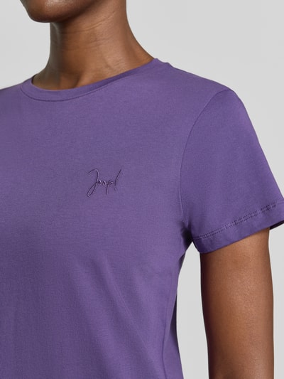 Kobieta prezentuje damski t-shirt Regular Fit T-Shirt aus reiner Baumwolle od JOOP! w kolorze fioletowym, z bliska na górną część ciała