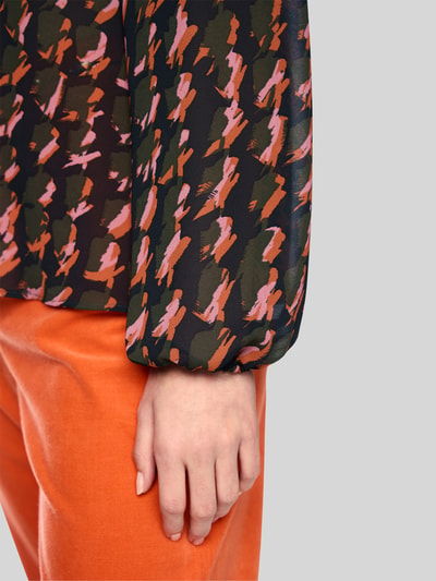 Vrouwenmodel draagt Regular Fit blouse in all-over look met druppelvormige hals van Marc Cain, chiffon, detailopname onderarm. Ruglengte bij maat 36: 61 cm, mouwlengte bij maat 36: 64 cm.