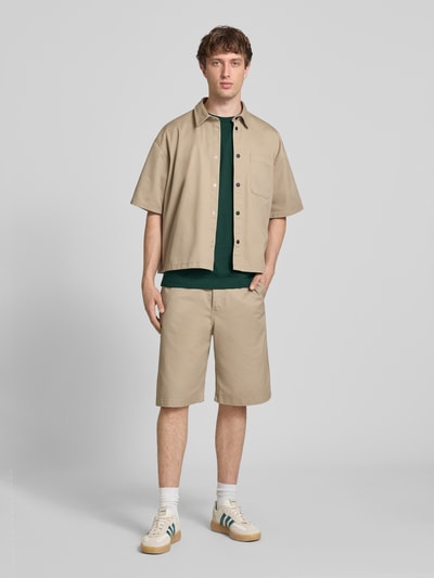 Männermodel trägt Loose Fit T-Shirt aus reiner Baumwolle Modell 'LES CLASSIQUES' von Only & Sons, Optik: Unifarben, Passform: Loose-Fit, Applikation: Schriftzug, Rundhals, Ärmelform: Kurzarm, Materialverarbeitung: Jersey; Ganzkörperansicht von vorne.