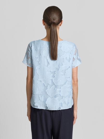 Frauenmodel trägt Blusenshirt aus Viskose-Mix mit Strukturmuster von More & More, hellblau, gerader Schnitt, Ganzkörperansicht Rückansicht.