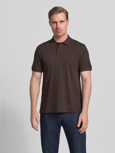Männermodel trägt Regular Fit Poloshirt aus reiner Baumwolle Modell 'PALLAS' von BOSS, Optik: Unifarben, Piqué, Ganzkörperansicht von vorne.