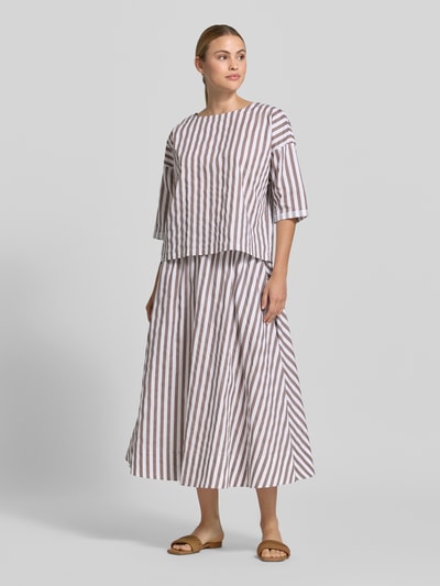 Frauenmodel trägt Relaxed Fit Bluse mit U-Boot-Ausschnitt von Rich & Royal aus Reine Baumwolle, braun-weiß gestreift, Halbarm, Ganzkörperansicht von vorne.