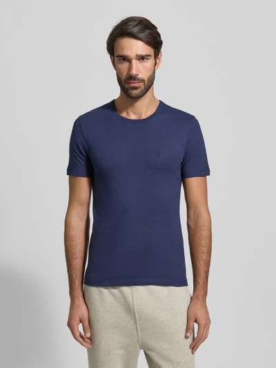Männermodel trägt T-Shirt mit Label-Stitching im 3er-Pack Modell 'Classic' von BOSS, Baumwolle, unifarben, gerade geschnitten, Ganzkörperansicht von vorne.