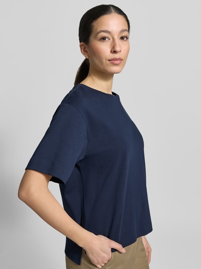 Frauenmodel trägt Regular Fit T-Shirt aus reiner Baumwolle Modell 'MULTID' von Weekend Max Mara in Optik: Unifarben, Logo-Print, Rundhals, Kurzarm, Feinripp, Rumpfabschluss: asymmetrisch mit Seitenschlitzen, Ganzkörperansicht von vorne.