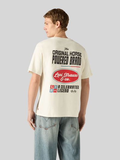 Männermodel trägt Relaxed Fit T-Shirt aus reiner Baumwolle von Levi's®, cremefarben mit großem Print, Struktur glatt, Ganzkörperansicht Rückansicht.