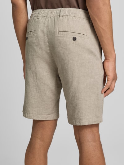 Männermodel trägt Slim Fit Bermudas aus Baumwoll-Leinen-Mix Modell 'BRODY' von SELECTED HOMME, efekt: jednolity kolor, krój slim fit, aplikacja z metką, szlufki na pasek, zapięcie na guzik i zamek błyskawiczny, tunel, wpuszczana kieszeń, kieszeń z tyłu, mieszanka bawełny i lnu, Ganzkörperansicht Rückansicht