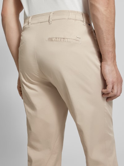 Männermodel trägt Chino mit Eingrifftaschen Modell 'Tino' von BRAX, Baumwoll-Elasthan-Mix, Regular-Fit, Gelegte Falten, Ganzkörperansicht Rückansicht.