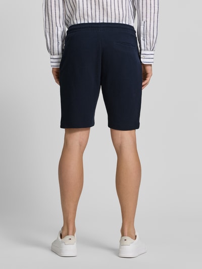 Männermodel trägt Shorts aus Baumwolle mit Strukturmuster von Christian Berg Men in Dunkelblau, Regular-Fit, elastischer Bund, Ganzkörperansicht Rückansicht