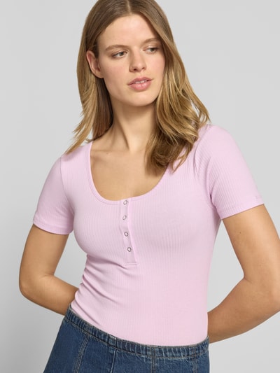 Frauenmodel trägt Slim Fit T-Shirt aus Baumwoll-Mix Modell 'KITTE' von Pieces in zartem Rosa, unifarben, gerippte Struktur, Nahaufnahme Oberkörper.