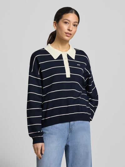 Frauenmodel trägt Gestuz Strickpullover mit Polokragen Modell 'taige' im Oversized-Look, dunkelblau mit weißen Streifen, Nahaufnahme Oberkörper.