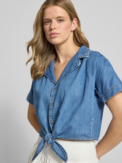 Frauenmodel trägt Cropped Jeansbluse aus reiner Baumwolle Modell 'PAULA' von Only in mittlerem Blau, Damen Jeansbluse, Nahaufnahme Oberkörper.