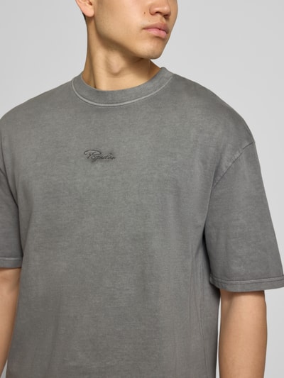 Männermodel trägt Oversized Herren T-Shirt mit Rundhalsausschnitt aus reiner Baumwolle, Pegador Oversized T-Shirt mit 1/2-Arm Modell 'Towson', grauer Farbton, Struktur glatt, Rückenlänge bei Größe M 69 cm, Nahaufnahme Oberkörper.