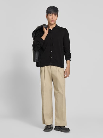 Männermodel trägt Strickjacke mit Polokragen Modell 'CAMICIA IN MAGLIA' von MARKUP, Reine Baumwolle, Slim-Fit, schwarz, Knopfleiste, Ganzkörperansicht von vorne.