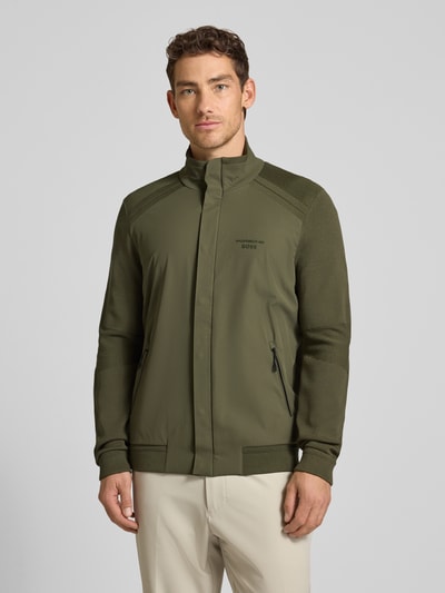 Männermodel trägt Regular Fit Blouson aus Modal-Mix mit Seiden-Anteil Modell 'SPIRIT70' von BOSS Green X PORSCHE in Oliv, unifarben, Ganzkörperansicht von vorne.
