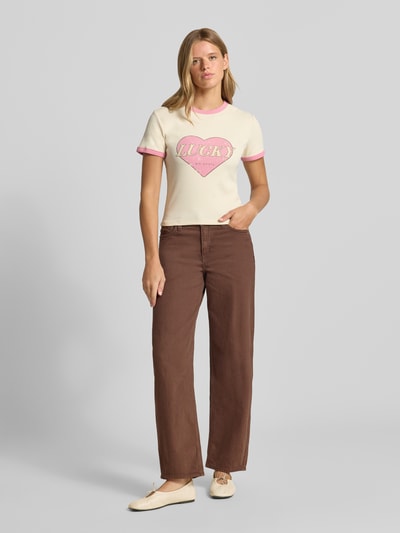 Frauenmodel trägt T-Shirt mit Motiv-Print Modell 'Lucky' von OH APRIL, creme mit rosa, Baumwoll-Mix, Regular Fit, Ganzkörperansicht von vorne.