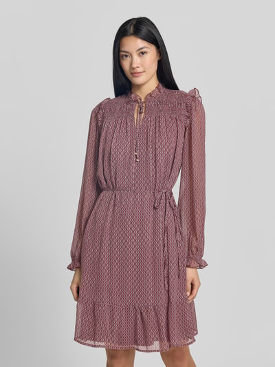 Frauenmodel trägt Knielanges Kleid mit Bindegürtel von Christian Berg Woman Selection in A-Linie mit Smok-Details und Allover-Muster, Ganzkörperansicht von vorne.